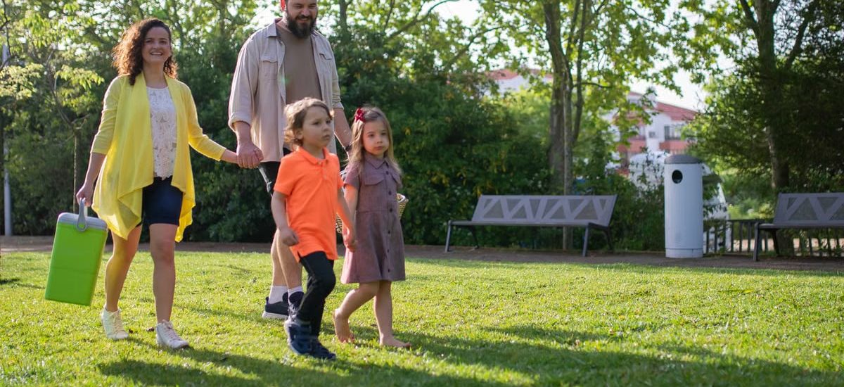 A joyful family with children strolling in a sunny Portuguese park.