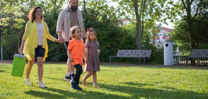 A joyful family with children strolling in a sunny Portuguese park.