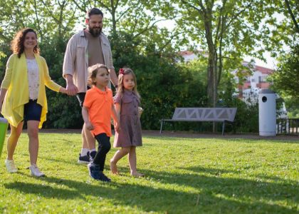 A joyful family with children strolling in a sunny Portuguese park.